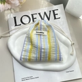 Close-up of seersucker striped drawstring pouch with Sozakka label on a white tray - Bubble Yellow Stripes