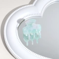 Detail of mint green marble acetate hair claw clip reflected on a white heart mirror - Teal
