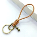 Handmade tan leather keychain with bronze horseshoe buckle and a small bell pendant - Natural Leather Rope Bronze Horseshoe Buckle with Bead