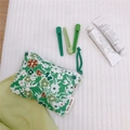Detailed top view of a green floral cotton mini coin purse with simple wish woven label - Dark Green Background Floral