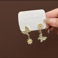 Asymmetric gold earrings with crystal butterfly and white enamel daisy charms - Daisy Butterfly Earrings