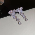 Close-up of sparkling zircon butterfly tassel earrings with silver finish on reflective base - Silver Flower Water Drop Earrings
