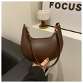 Close-up of a dark brown crescent underarm bag in smooth PU leather with gold hardware details - Coffee