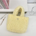 Detalle del bolso tote de felpa amarilla suave con etiqueta Sozakka en escritorio blanco - Amarillo tierno