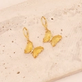 Macro detail of golden butterfly earrings with yellow crystal wings and micro diamonds - Yellow
