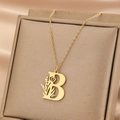 Detail der goldenen Halskette mit Buchstabe B Anhänger und feinem Blumenmuster - Buchstabe B