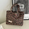 Nahaufnahme der Leoparden-Plüschhandtasche mit rosa-brauner Textur und Markenetikett - Handheld Leopard Violett Rosa