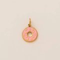 Close-up of golden donut pendant with pink enamel and polished metallic finish - Donut