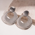 Detailed view of silver textured hollow round earrings on a natural stone background - Silver