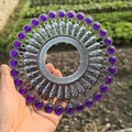 Detail of silver metal round wall decor featuring inlaid purple beads held in a garden - Retro Silver Purple Rhinestone