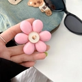 Close-up of pink flower phone grip with a golden heart on a blue denim background - Pink