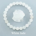 Macro shot of 8mm white jade bead bracelet on raw mineral stone for jewelry detail - White Jade