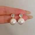 Elegant gold pearl earrings featuring round clear zircon studs and large white pearls - Prong Set Zircon Pearl Drop