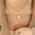 Taurus constellation pearl necklace with gold shell pendant on a female model - Taurus