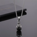 Gros plan du pendentif griffe de dragon argentée avec pierre noire sur chaîne acier - Griffe Perle Noire