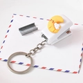 Mini white cartoon stapler keychain with a yellow moon charm on a decorative envelope - Cute Moon