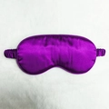 Silk satin sleep eye mask in elegant purple with elastic strap on white plush surface - Purple
