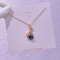 Détail du collier léopard doré orné de zircons et d'une perle bleue au design cosmique - Léopard Étoilé (XK003)