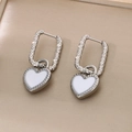 Vue détaillée de boucles d'oreilles cœur en argent avec émail blanc et fini ondulé - Acier-Blanc