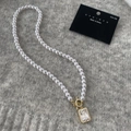 Dettaglio collana di perle con ciondolo in zircone quadrato e chiusura a levetta dorata - Stile Zirconia Quadrata