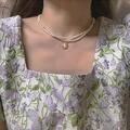 Double-layer pearl choker necklace with a vintage round pendant on a model - Double Layer Pearl Choker with Vintage Pendant