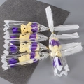 Close-up of five mini bear figurines holding purple soap roses in clear gift packaging - Purple