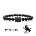Detailed macro view of Capricorn matte black beaded bracelet with gold spacers and zodiac charm - Capricorn