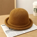 Close-up of caramel knit bucket hat texture on a wooden table with newspaper - Dark Khaki
