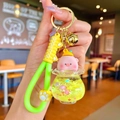Détail de porte-clés cochon avec bouteille de sable liquide et sangle jaune avec clochette - Cochon Pêche Flocon de Neige Lumineux Jaune