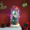 Macro shot of illuminated mini Christmas tree with silver bells in a clear glass dome - Style 4