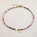 Detail of colorful beaded necklace with golden letter D pendant and white heart charm - Letter D