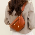 Bolso bandolera retro de cuero suave marrón en forma de media luna mostrado en modelo - Marrón