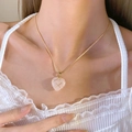 Detail van roze kristallen hart hanger met gouddraad op een gouden slangenketting - Barbie Stijl KC Goud Roze A-346