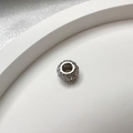 Macro shot of S925 silver spacer bead with cubic zirconia on white tray with silk backdrop - Silver