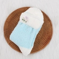 Calze in pile di corallo blu chiaro e bianco in un vassoio intrecciato decorativo - Blu lago