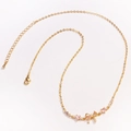 Detailed view of a gold O-chain necklace featuring a pink bow pendant with inlaid zircons - Gold