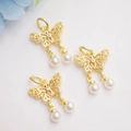 Detail eines 14K vergoldeten Hohl-Schmetterling-Anhängers mit Zirkonia und Perlen - Antikgold/Weißer Zirkon