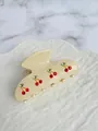 Detail of cream acetate hair claw clip featuring sparkling red rhinestone cherries - Approx. 8cm / Beige