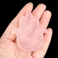 Pink rose quartz Hamsa hand figurine with carved evil eye detail on a black background - Rose Quartz