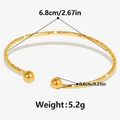 Dettaglio di un bracciale aperto in oro 18k con texture martellata e misure in pollici - Oro