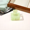 Detail view of light green marble texture acrylic shark hair claw clip on wooden tray - PVC 5cm Square - Iridescent Green