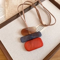 Dettaglio di pendenti rettangolari in acrilico ambra, blu e arancione su collana lunga - Rosso-Blu