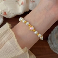 Elegant pearl and gold bead bracelet with oval pink opal center on female wrist - Purple Cat's Eye Pearl (MY37202)