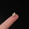 Golden fan-shaped tragus piercing stud with four trapezoid zircons held on a fingertip - Fan Radiant Style (319-6#G)