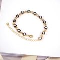 Dettaglio del bracciale boho dorato con perline malocchio blu e zirconi scintillanti - Nero