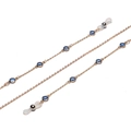 Detailed macro view of crystal glasses chain with blue beads and gold links - Blue