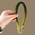 Detalle de diadema de terciopelo verde esmeralda con colgantes de borlas doradas vintage - Diadema Verde Oliva