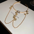 Dettaglio della collana a farfalla dorata con catene eleganti su una scatola regalo - Bracciale da Braccio Oro