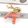 Detail of pink resin letter T keychain with glitter, metal bee charm and leather tassel - Letter T Bee Keychain
