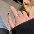 Detail eines goldenen Rings mit Katzenaugenstein und funkelndem Stern aus Kristallen - Gold / Öffnung Einstellbar